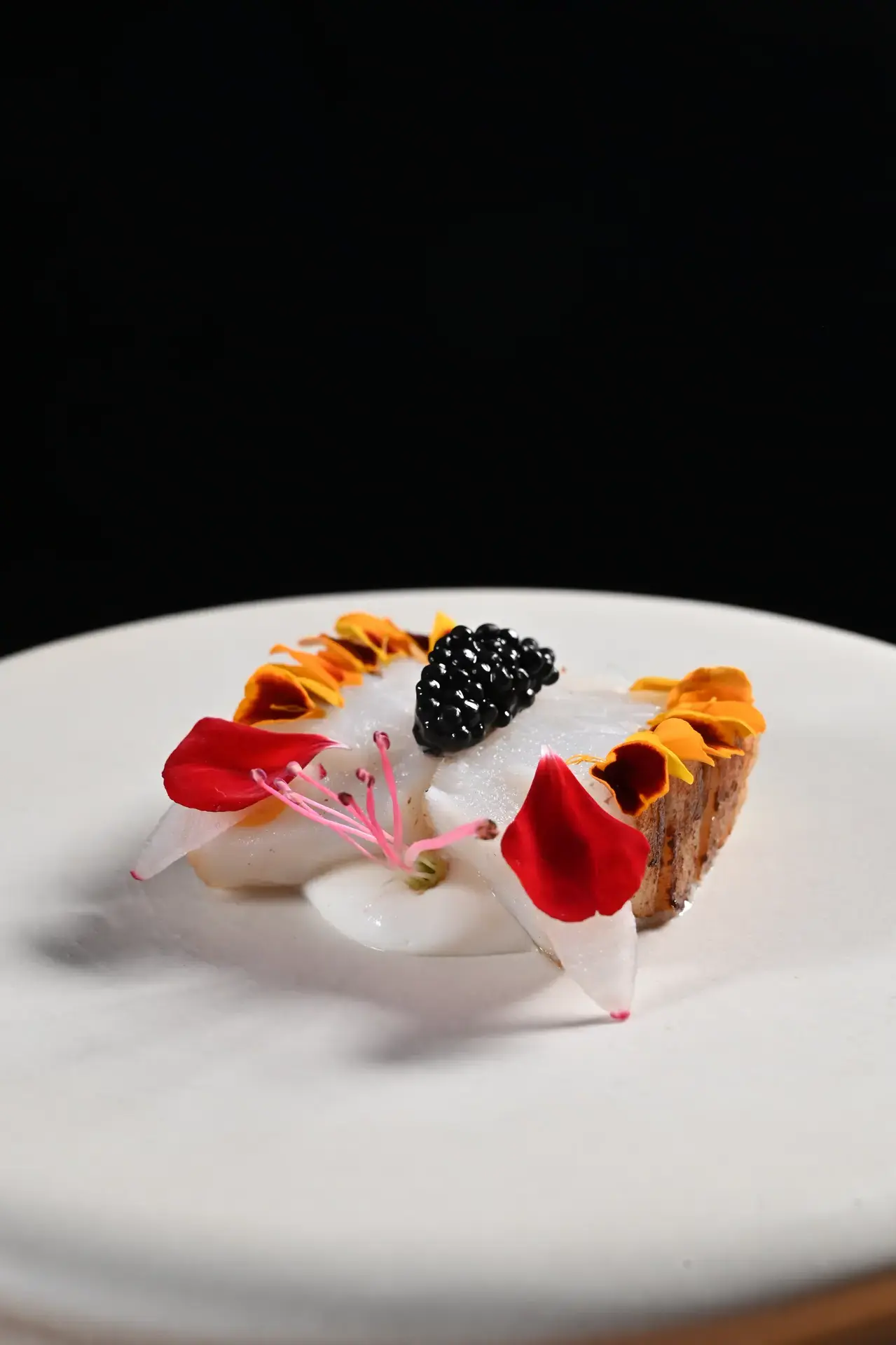 Piatto d'autore con caviale e fiori commestibili